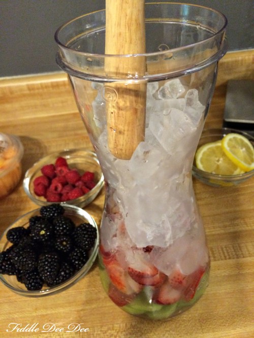 Releasing the fruit juice into the pitcher using a wooden pestle
